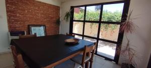 a dining room with a black table and a large window at Casa D a 2 - Con Parrilla - Centro de Federación in Federación