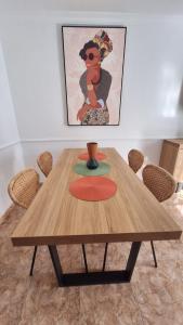 drewniany stół z krzesłami i zdjęcie na ścianie w obiekcie FRANCY PLACE w mieście Costa Del Silencio