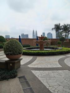 einen Brunnen in einem Park mit einer Stadt im Hintergrund in der Unterkunft Bunga Suite at Times Square in Kuala Lumpur