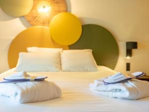 una camera d'albergo con un letto e asciugamani di Mercure Auxerre Autoroute du Soleil ad Appoigny