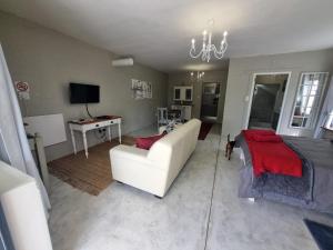 sala de estar con sofá blanco y almohadas rojas en Manatoka Unit 2, en Jacobs Bay