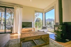 a living room with a table and a large window at Ville Views in Harrietville