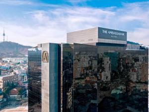 a large building with a sign on top of it at The Ambassador Seoul - A Pullman Hotel in Seoul