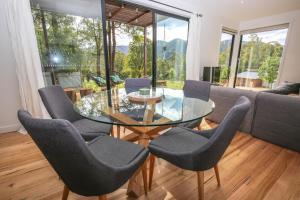 a dining room with a glass table and chairs at Ville Views in Harrietville