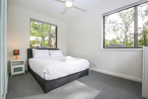 a white bedroom with a bed and a window at Ville Views in Harrietville