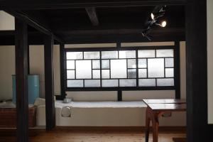 Zimmer mit einem Fenster mit einer Bank und einem Tisch in der Unterkunft TOSAYAMA BASE 清流沿いの里山　古民家貸切　高知市街地より車で約20分 in Kōchi