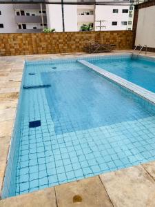 une grande piscine d'eau bleue dans l'établissement Apartamento Condominio Emilio Hinko - Beira Mar, à Fortaleza