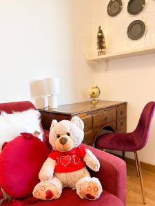um urso de peluche sentado numa almofada vermelha em Como view apartment em Como