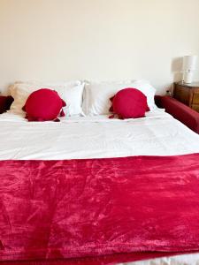 a bed with two red pillows on top of it at Como view apartment in Como