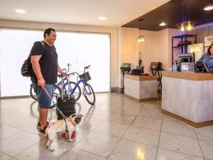 リオデジャネイロにあるibis Copacabana Posto 2の犬を紐につけた男