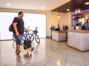 un hombre con un perro con una correa en una tienda en ibis Copacabana Posto 2, en Río de Janeiro