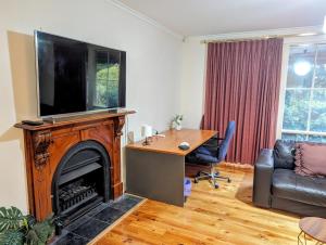 een woonkamer met een televisie boven een open haard bij Spacious, Modern & Stylish Vacation Home in Seaton