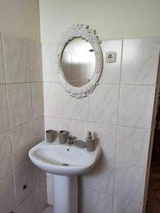 La salle de bains est pourvue d'un lavabo blanc et d'un miroir. dans l'établissement Casa Andrade Delgado - Rotxa Grande, à Ponta do Sol