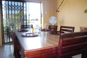 einem Holztisch mit Stühlen und einem Esstisch in der Unterkunft Lapeng La Heso guest in Mogwase