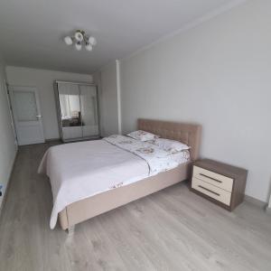 a bedroom with a bed and a dresser and a mirror at ApartHotel city centrum in Chişinău