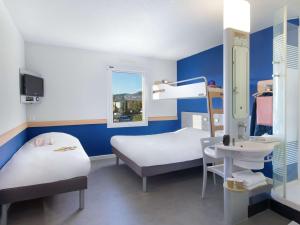Habitación hospitalaria con 2 camas y lavamanos en ibis budget Saint-Maximin en Saint-Maximin-la-Sainte-Baume