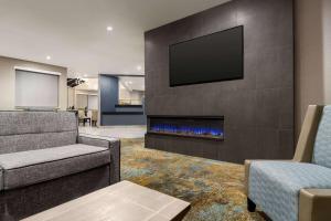 a living room with a fireplace with a tv on a wall at La Quinta by Wyndham Round Rock North in Round Rock