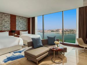 une chambre d'hôtel avec un lit et un canapé dans l'établissement Fairmont Bab Al Bahr, à Abu Dhabi