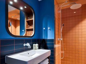 a bathroom with a white sink and a mirror at 25hours Hotel Hamburg HafenCity in Hamburg