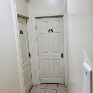 una porta bianca con dei numeri sopra in un corridoio di STUDIO and ONE BEDROOM APARTMENTS a Bronx
