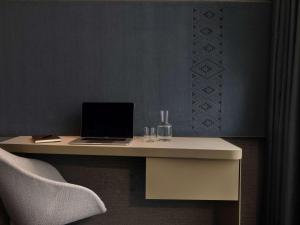 a desk with a laptop and a chair on it at Pullman Auckland Airport in Auckland