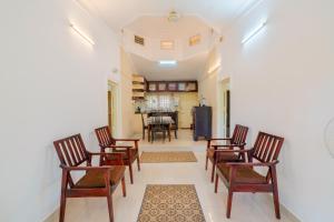 a living room with chairs and a dining room at Nature Routes Cottage in Munnar