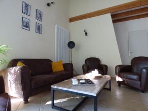 a living room with two couches and a coffee table at La Patte Charentaise Parking gratuit Le calme en ville in Saintes