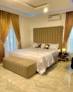 a bedroom with a large bed with a large headboard at Blueprint Apartment in Akure