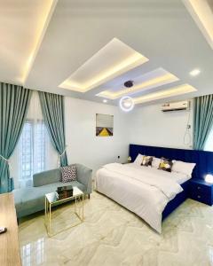 ein Schlafzimmer mit einem großen Bett und einem Sofa in der Unterkunft Blueprint Apartment in Akure