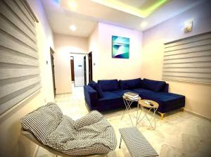 a living room with a blue couch and a table at Blueprint Apartment in Akure +19 photos