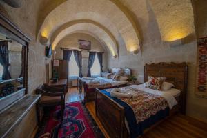 a bedroom with two beds in a room with an archway at Safran Cave Hotel in Goreme