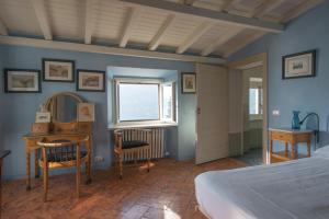 a bedroom with a bed and a desk and a window at Villa Intreccio in Blevio