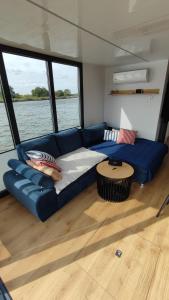 ein Wohnzimmer mit einer blauen Couch auf einem Boot in der Unterkunft Houseboat Water King apartament pływający dom na wodzie łódź Hausboot 7 os in Uraz