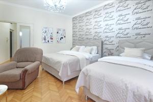 a bedroom with two beds and a chair at Illusion Downtown Apartment in Belgrade