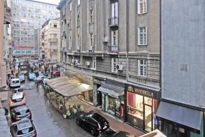 a busy city street with parked cars and buildings at Illusion Downtown Apartment in Belgrade