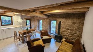 eine Küche und ein Wohnzimmer mit einer Steinmauer in der Unterkunft El Najerilla. Casa de pueblo in Villavelayo
