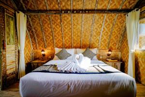 1 dormitorio con 1 cama grande en una habitación en Alvia Joglo House & Private Pool en Tampaksiring