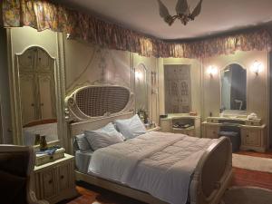 a bedroom with a large bed and a mirror at WB Lounge - Mohandessin Apartment in Cairo