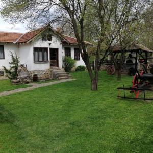 uma casa branca com um quintal com uma mesa de piquenique em ETNO KOMPLEX NIKOLOV em Dimitrovgrad