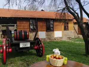 uma carruagem puxada por cavalos em frente a uma cabina de madeira em ETNO KOMPLEX NIKOLOV em Dimitrovgrad