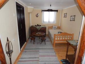 a small bedroom with a bed and a table at ETNO KOMPLEX NIKOLOV in Dimitrovgrad