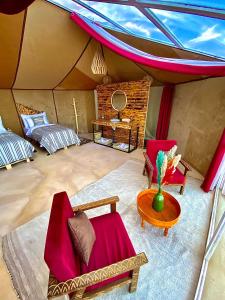 uma tenda com duas cadeiras e uma mesa num quarto em Sky View Camp em Merzouga