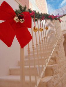 un escalier blanc avec un arc rouge sur celui-ci dans l'établissement Antica Dimora, à Lizzano