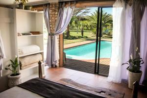 a bedroom with a view of a swimming pool through a door at Place of Sonlight in Swellendam
