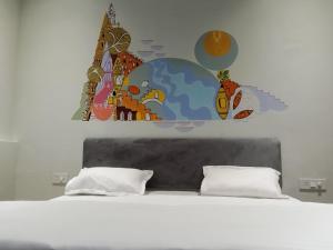 een slaapkamer met een bed met een muurschildering aan de muur bij MY ROOMZ BANARAS in Varanasi