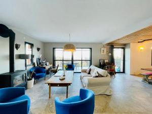 a living room with blue chairs and a couch at Les Vignals gîtes et événements Cévennes in Arphy