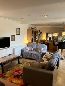 a living room with a couch and a table at Bright central large cosy flat in Fife