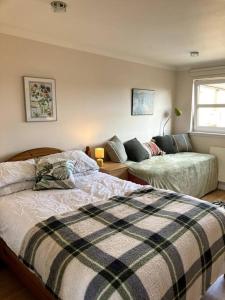 a bedroom with a bed and a couch at Bright central large cosy flat in Fife