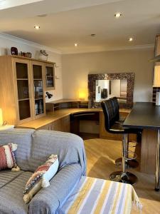 a living room with a couch and a table and a kitchen at Bright central large cosy flat in Fife