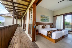 een slaapkamer met een bed en een balkon bij Angan-Angan Villas in Canggu